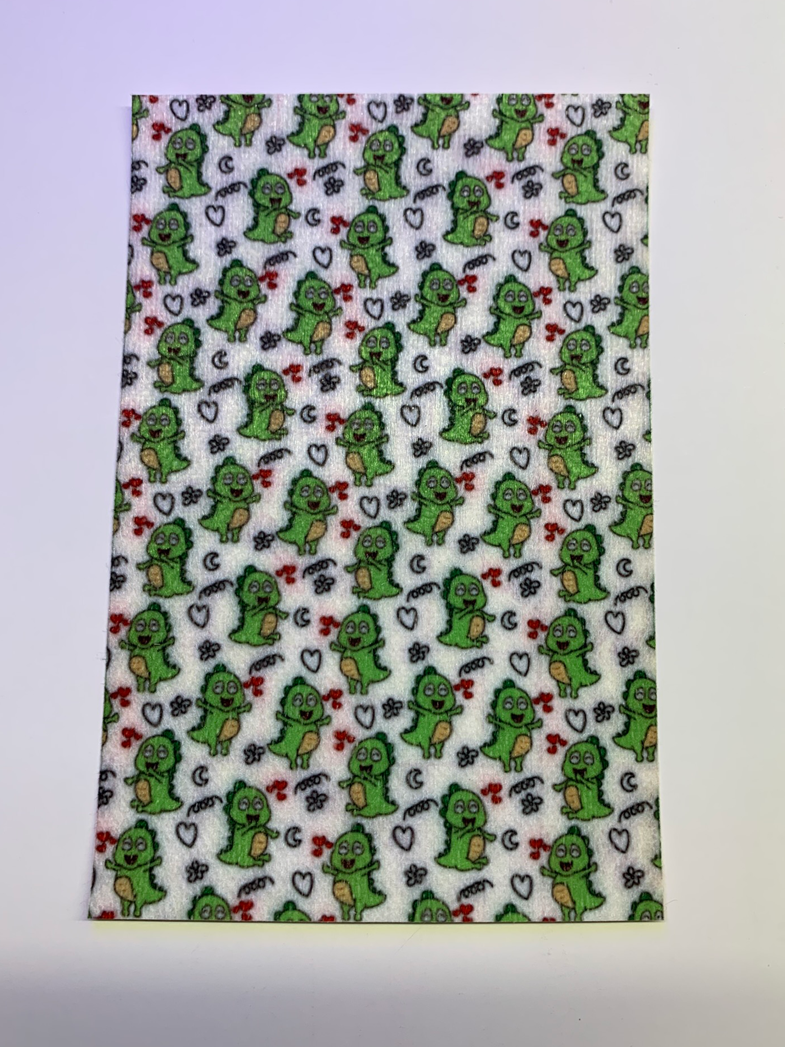 4x6" tubie tape featuring a white background with small green cartoon dinosaurs in a repeating pattern. Includes hearts, stars, and playful doodle accents in black and red. Fun, whimsical, and kid-friendly design.
