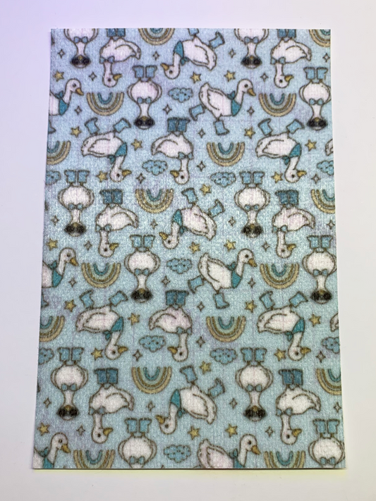 4x6" tubie tape featuring a light blue background with white geese wearing blue boots and hats in a repeating pattern. Includes small stars, clouds, and rainbow shapes in soft muted tones. Playful, whimsical, and nursery-inspired design.