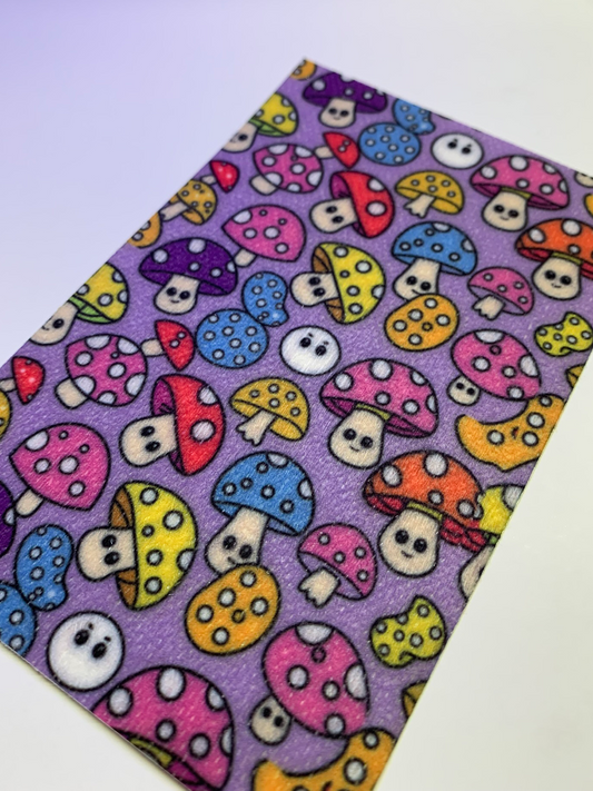 4x6" tubie tape featuring a purple background with colorful mushrooms in a repeating pattern. Mushrooms include pink, blue, yellow, red, and orange caps with white spots and cute faces. Bright, playful, and whimsical design.
