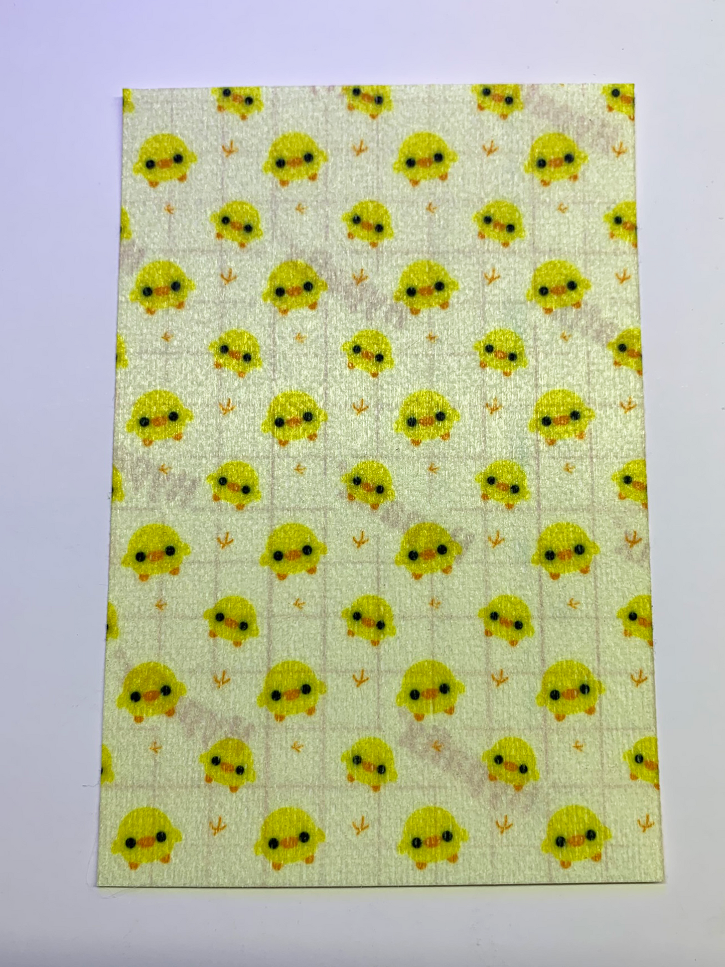 4x6" tubie tape featuring a soft pastel yellow background with small kawaii-style yellow chicks in a repeating pattern. Each chick has simple black eyes and orange beaks, with tiny footprints between them. Cute, minimal, and baby-inspired design.