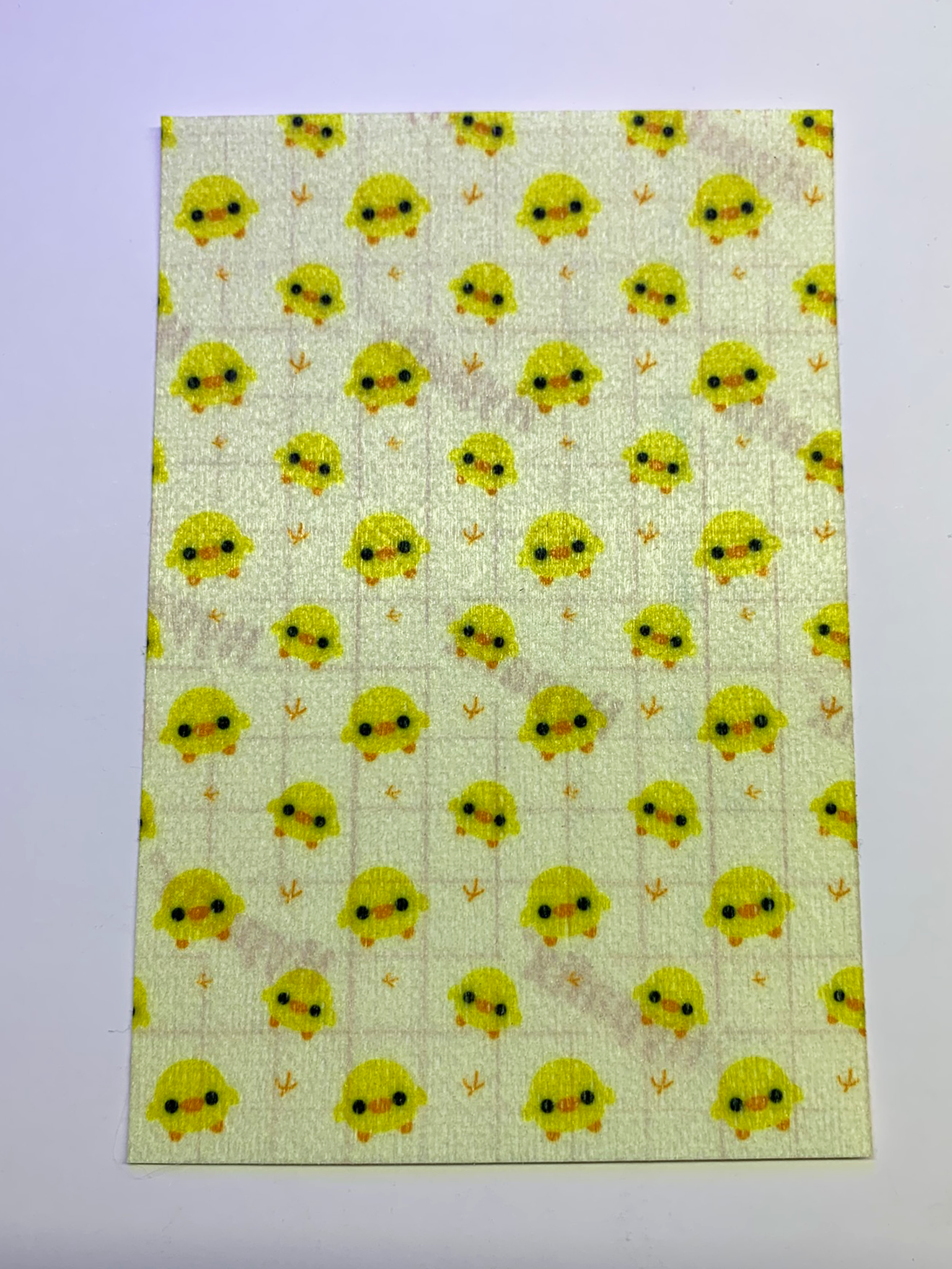 4x6" tubie tape featuring a soft pastel yellow background with small kawaii-style yellow chicks in a repeating pattern. Each chick has simple black eyes and orange beaks, with tiny footprints between them. Cute, minimal, and baby-inspired design.
