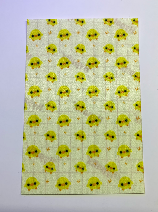 4x6" tubie tape featuring a soft pastel yellow background with small kawaii-style yellow chicks in a repeating pattern. Each chick has simple black eyes and orange beaks, with tiny footprints between them. Cute, minimal, and baby-inspired design.