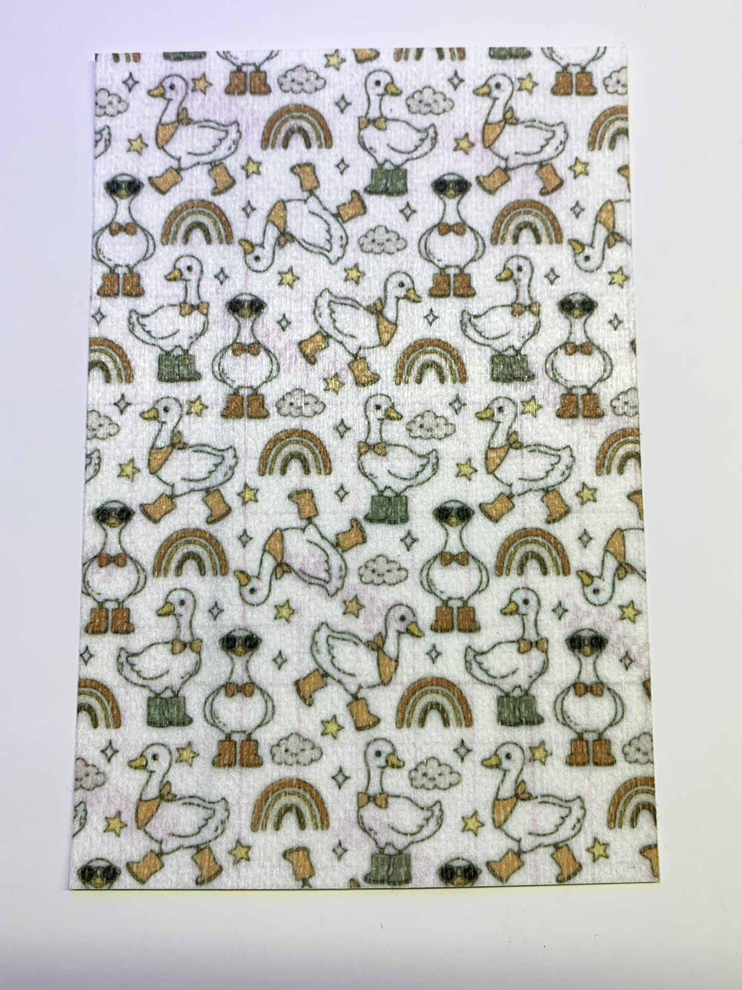 4x6" tubie tape featuring a white background with geese wearing boots and bow ties in a repeating pattern. Includes rainbows, clouds, and stars in earthy neutral tones. Simple, playful, and rustic-inspired design.
