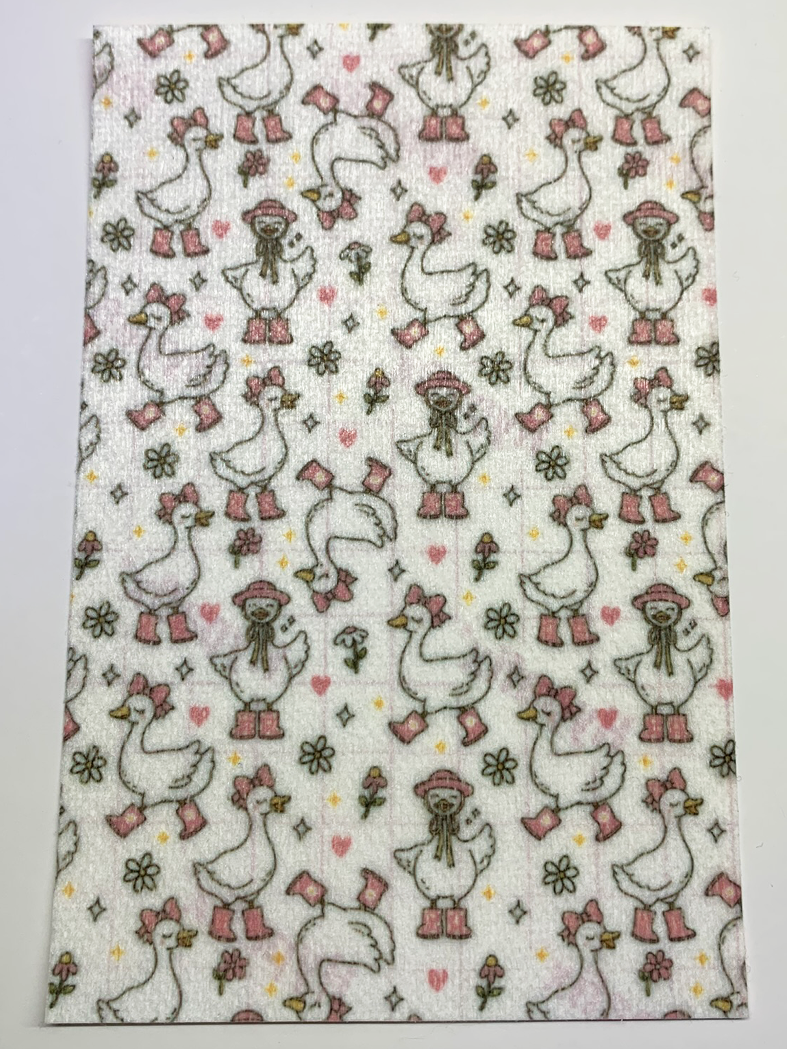 4x6" tubie tape featuring a white background with geese wearing pink boots, bows, and hats in a repeating pattern. Includes flowers, hearts, and small accents in soft pastel tones. Cute, feminine, and playful design.
