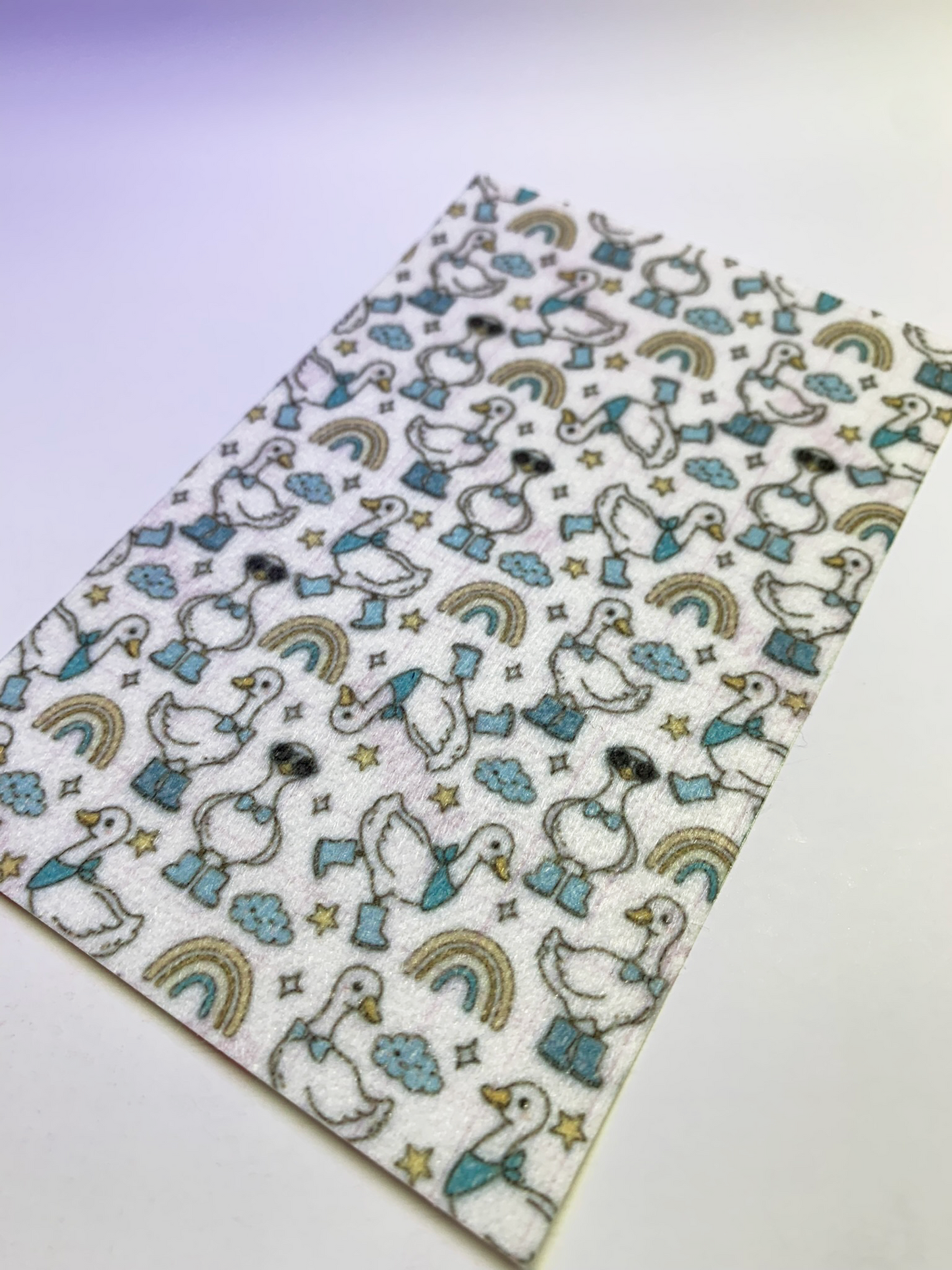 4x6" tubie tape featuring a white background with geese wearing blue boots and bow ties in a repeating pattern. Includes rainbows, clouds, and stars in soft neutral tones. Cute, playful, and whimsical design.

