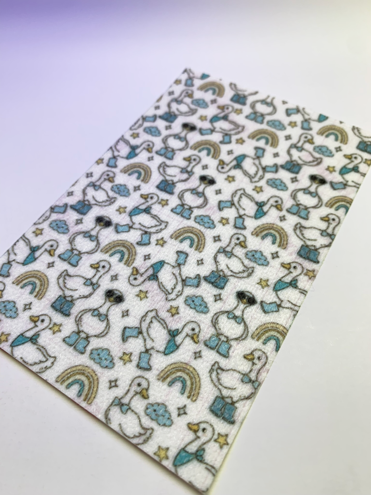 4x6" tubie tape featuring a white background with geese wearing blue boots and bow ties in a repeating pattern. Includes rainbows, clouds, and stars in soft neutral tones. Cute, playful, and whimsical design.
