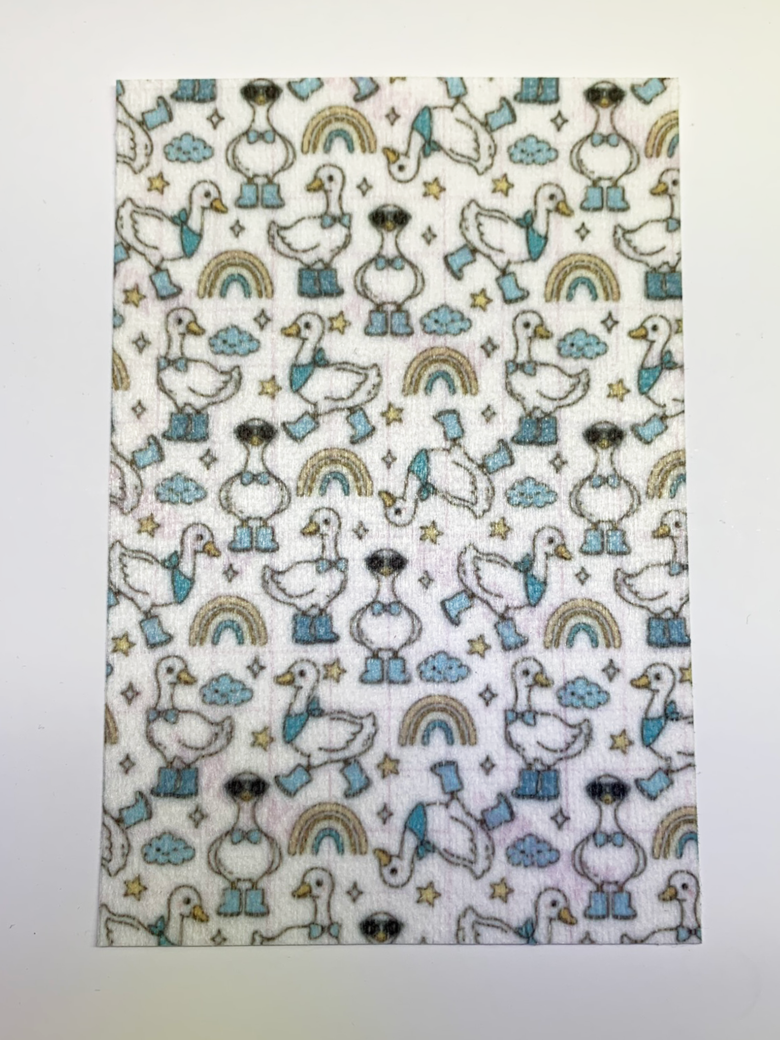 4x6" tubie tape featuring a white background with geese wearing blue boots and bow ties in a repeating pattern. Includes rainbows, clouds, and stars in soft neutral tones. Cute, playful, and whimsical design.
